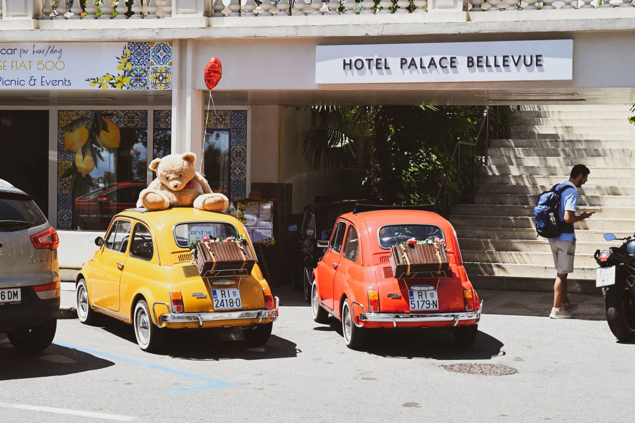 Classic Fiat 500 cars with a teddy bear and picnic baskets in Opatija, Croatia.